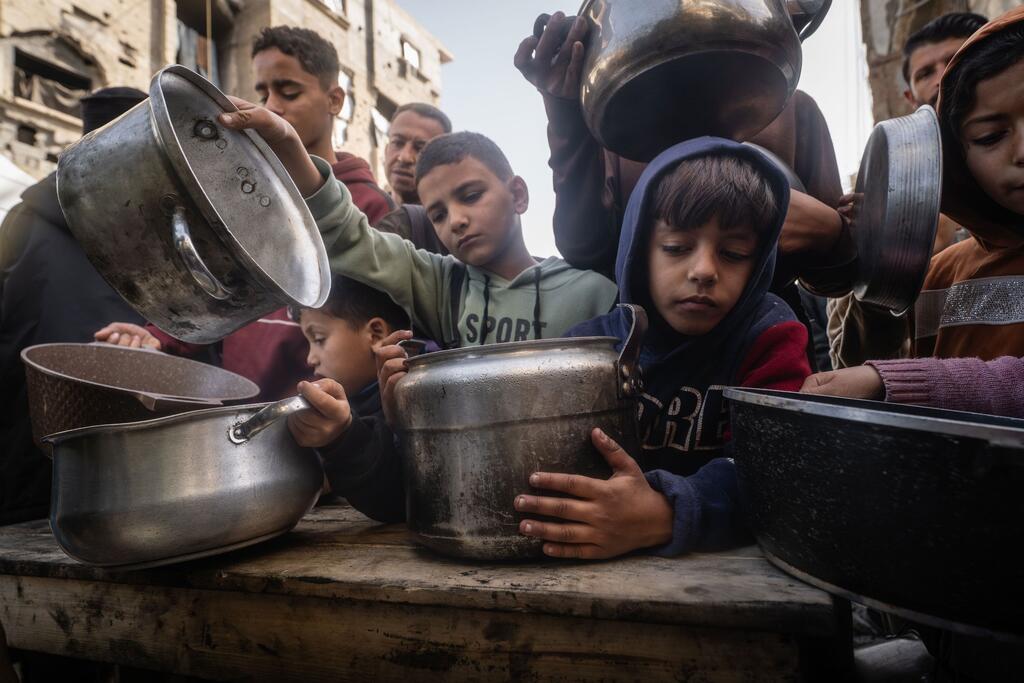 Les enfants de Gaza reçoivent des repas chauds pendant le Ramadan dans une cuisine communautaire, ce qui souligne l'impact des déplacements et de l'aide humanitaire.